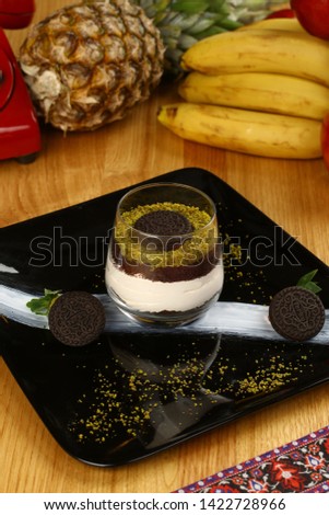 Magnolia pudding dessert with chocolate and cream in glass and chocolate biscuits