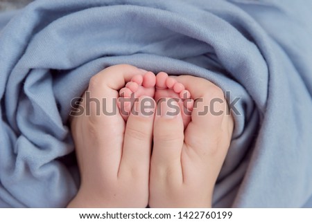 Tiny fingers, toes and feet of newborn baby boy 23 days old