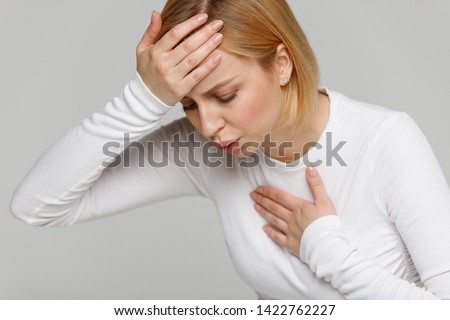 Breathing, respiratory problem, asthma attack, pressure, chest pain, sun stroke, dizziness concept. Studio portrait of woman received heatstroke in hot summer weather, touching her forehead, isolated Royalty-Free Stock Photo #1422762227