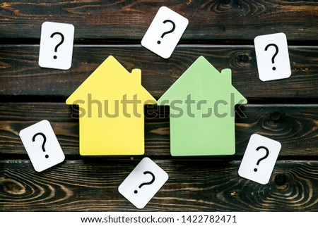 Mortgage credit concept with house toy and question mark on wooden background top view