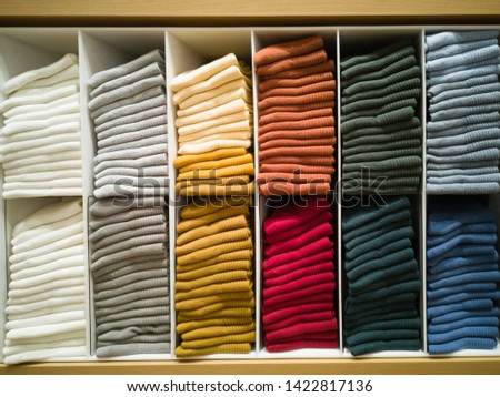 Cotton T-shirt folded neatly in the showroom,Colorful clothes folded in the cabinet,Colorful clothes neatly dressed,Shelves and multi-colored clothes in large stores,A row of colorful shirts. Royalty-Free Stock Photo #1422817136