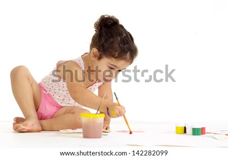 Little girl painting picture on a white background