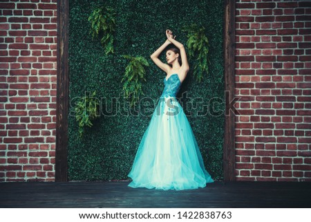 A full length portrait of a mysterious lady in a light blue dress posing indoor. Fairy tale, beauty, fashion.