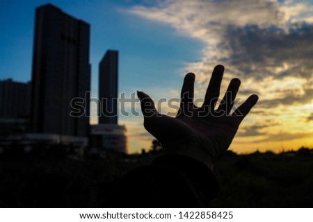 Pictures of hand movements with a blur sunset background