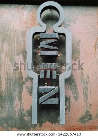 Male and female toilet or restroom sign in black with a rusty metal background