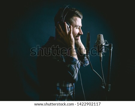 The young guy singing in recording studio Royalty-Free Stock Photo #1422902117