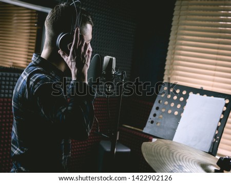 The young guy singing in recording studio Royalty-Free Stock Photo #1422902126