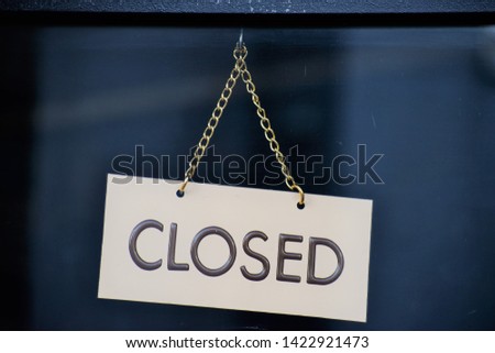 Hanging Closed Sign on a Chain on Glass
