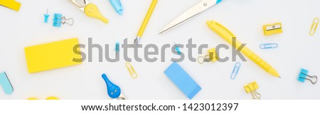 panoramic shot of mixed yellow and blue stationery isolated on white