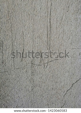 Old concrete surface with cracks and streaks.