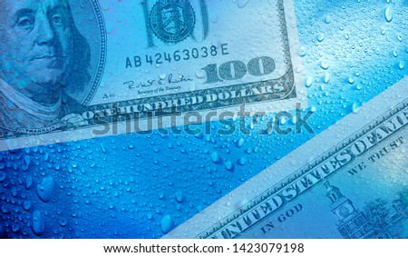 conceptual business and finance image of one hundred American dollar and raindrops 