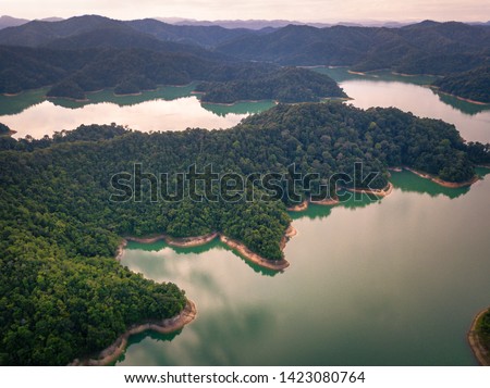 Top down aerial view by drone of a local dam in Kuala Nerang, Kedah. Ahning Dam is a multipurpose storage dam and habitat for flora and fauna. (blurry soft focus noise film grain visible)