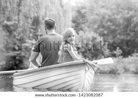 Black and White photo of 
Portrait of cute girl sitting with father on rowboat in lake during summer