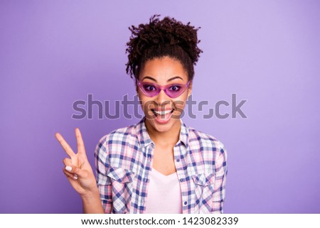Portrait of funny funky lovely teen teenager summer holiday weekend travel beautiful enjoy rejoice satisfied content make v-sign dressed checked shirt isolated on purple background