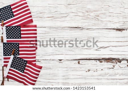 American Flags for the America's 4th of July Celebration over a white rustic background to mark America's Independence Day. Image shot from top view.