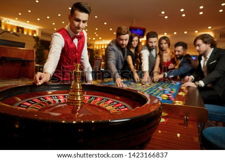 The croupier holds a roulette ball in a casino in his hand. Royalty-Free Stock Photo #1423166837