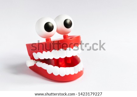 A smiling toy denture, chattering teeth with a spring that opens and closes by vibrating, with white teeth, ball eyes and gums, isolated on a uniform white background
 Royalty-Free Stock Photo #1423179227