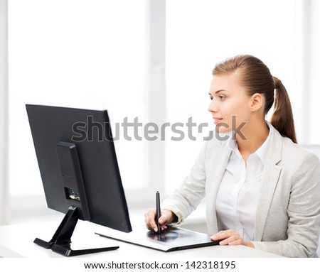 picture of smiling businesswoman with drawing tablet in office