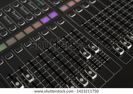closeup of sound mixer in recording studio with soft-focus and over light in the background