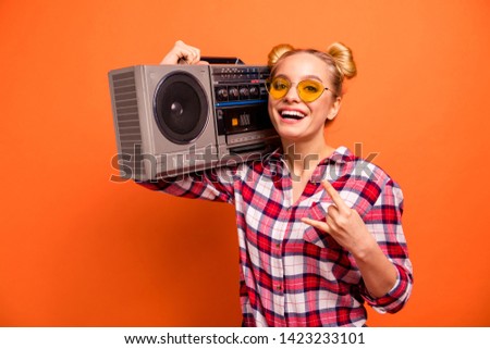 Close up photo beautiful nice she her nice lady toothy beaming smile vintage recorder shoulder hands arms horns symbol cool specs wear casual checkered plaid pink shirt isolated orange background