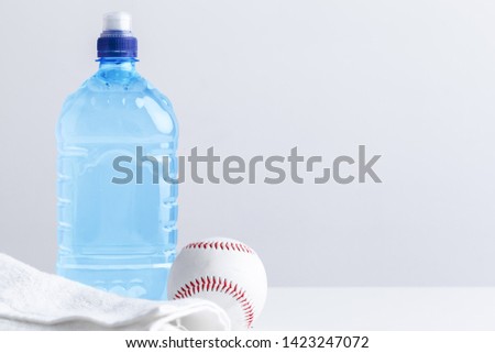 Sports bottle with towel on light background