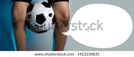 football goalkeeper with dirty knees clamped the ball between his legs on a blue background