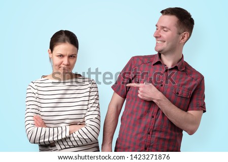 Brother pointing on his sister laughing on her problems. Man laughing at his girlfriend's failure. Royalty-Free Stock Photo #1423271876
