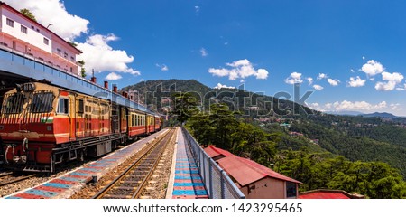 Toy train Kalka-Shimla route, standing on Shimla railway station with city in background. Shimla is state capital & tourist holiday destintation in the hill state Himachal Pradesh, India. Royalty-Free Stock Photo #1423295465