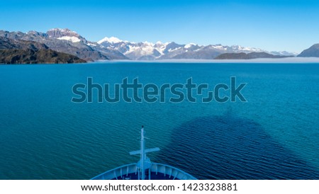 Cruise ship sailing in Glacier Bay National Park, Alaska. Breathtaking natural serene nature views. Spectacular sweeping vista of ice capped/ snow covered landscape of mountains, glaciers, wildlife.