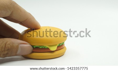 Rubber hamburger toy on bright background.                               