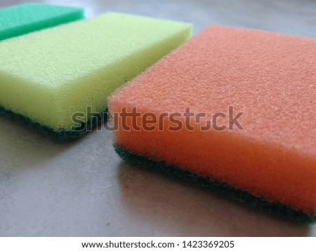 Colored sponges for the kitchen on the background of the table in the color of white marble.