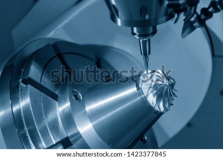 The 5-axis CNC milling machine cutting the turbine part with the taper ball endmill tool.The table tilt type of 5-axis machining center cutting the aero space parts. Royalty-Free Stock Photo #1423377845