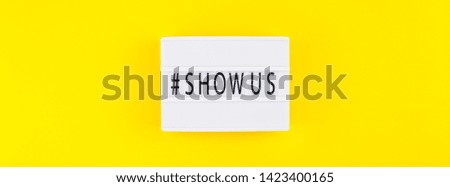 Creative top view flat lay of lightbox with hashtag Show Us message bold yellow background minimal style. 