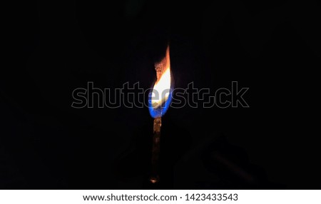 picture of a burning match stick having a beautiful curved flame at the head of the stick