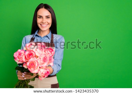 Portrait of charming attractive pretty lovely salesperson hold hand bunch feel content commercial rejoice enjoy occupation stylish trendy beautiful isolated green background