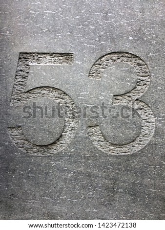 A Close Up Of The Number Fifty Three Carved Into Stone