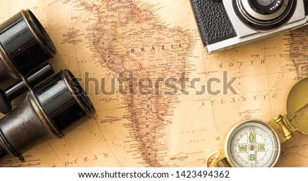 map of South America, Brazil among travelling accesories such as camera and compass