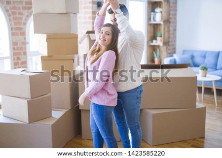 Young beautiful couple in love celebrating dancing moving to a new home, smiling very happy for new apartment