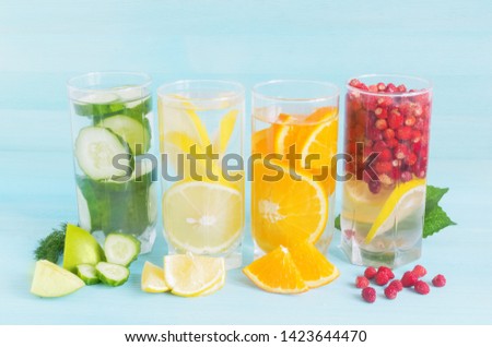 Lemonade of juicy fruit on a blue background. Summer cocktail of lemon, berries, cucumbers, orange in glass tall glasses Refreshing drink diet vegan food concept, fresh vitamins.Close-up.copy space