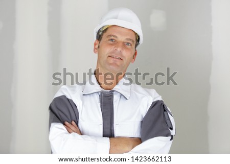 happy smiling worker in uniform with crossed arms