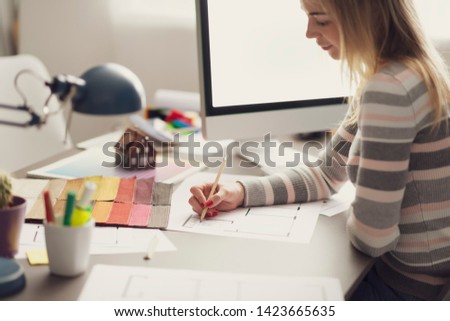 Professional interior designer working at desk and sketching on a house plan, creativity and decoration concept