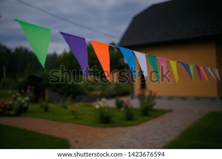 Triangular colorful holiday flags. Multicolored flags in the yard.