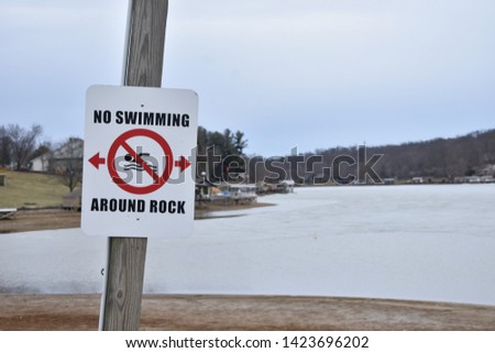 Lakeside with a "no swimming" sign