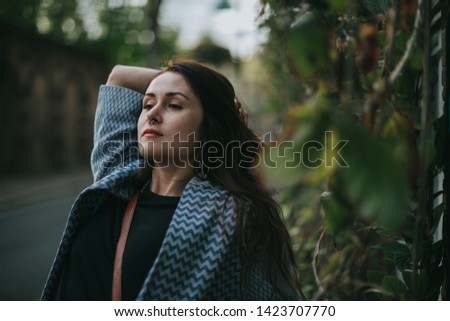 Picture of young female with nose piercing. Posing on the street in the evening.