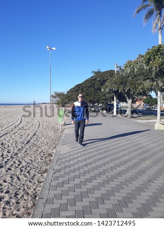 a 52-year-old man on the beach, exercising while walking and de-stressing