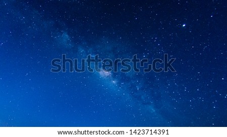 Milky Way with stars shining brightly beautiful at night on the sky background in Thailand Royalty-Free Stock Photo #1423714391