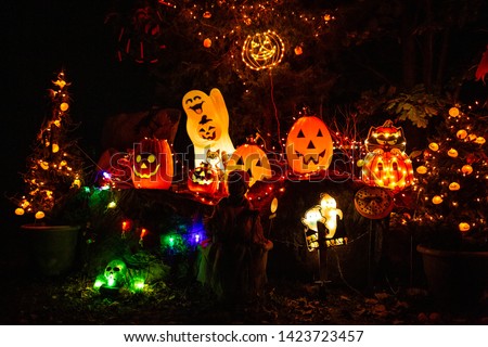 Scary Halloween decorations outdoors at night lighted