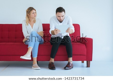 Woman bored and disregard to man sitting on couch in living room together,Family issues concept Royalty-Free Stock Photo #1423731734