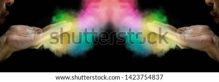 Man blowing colorful powder on hand