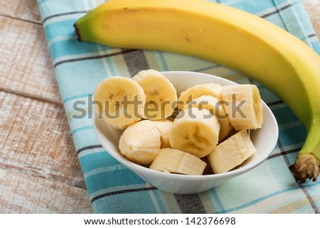 Fresh organic banana in bowl  on wooden background. Selective focus. Rustic style. Royalty-Free Stock Photo #142376698